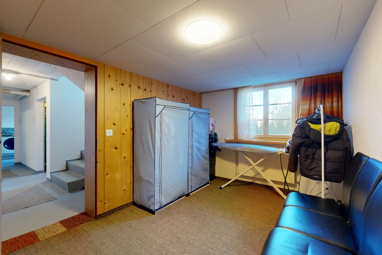 carpeted home office featuring wooden walls and washer / dryer