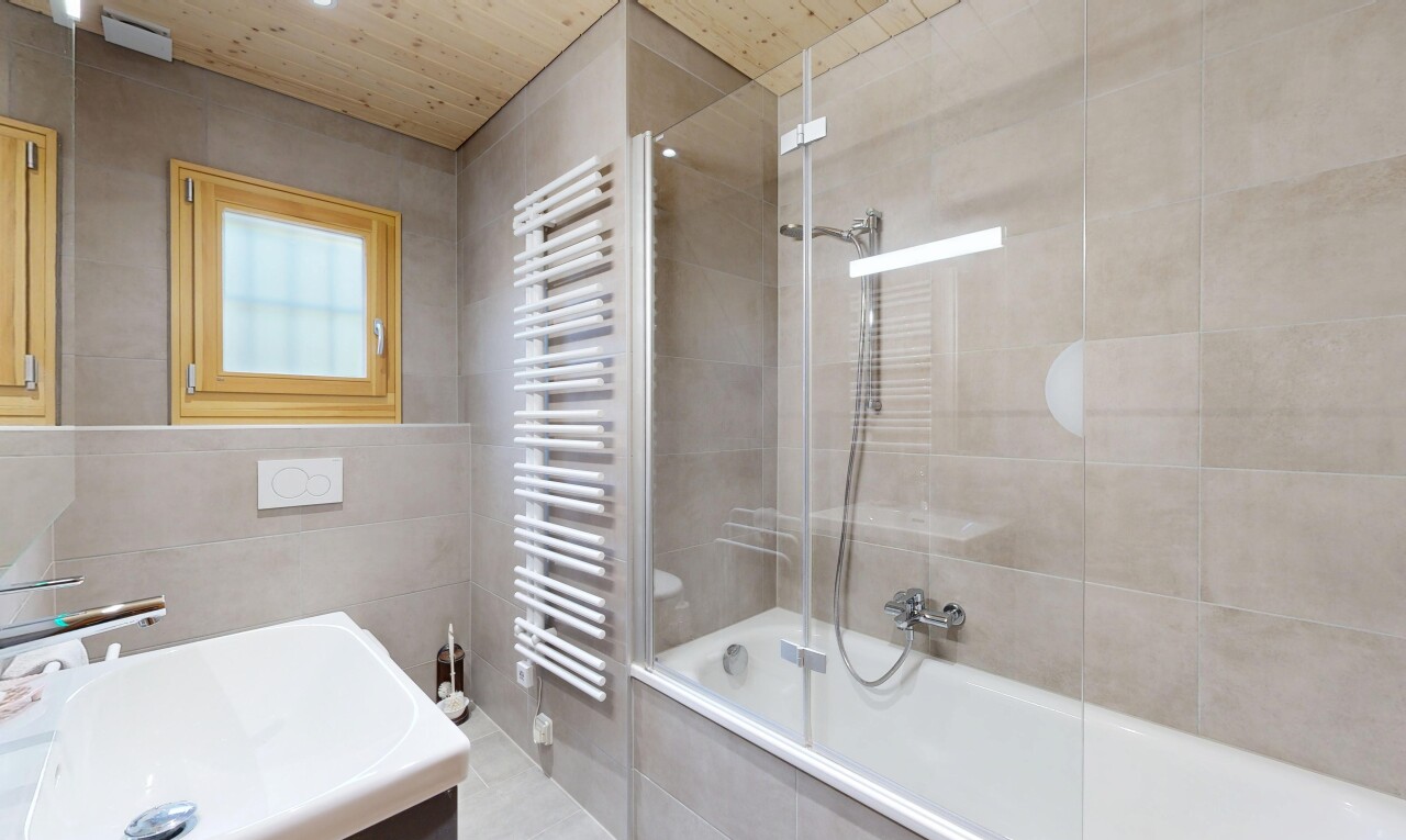 salle de bains avec chauffe-serviettes, douche-bain combinés, salle de bain complète, évier, et mur en carrelage