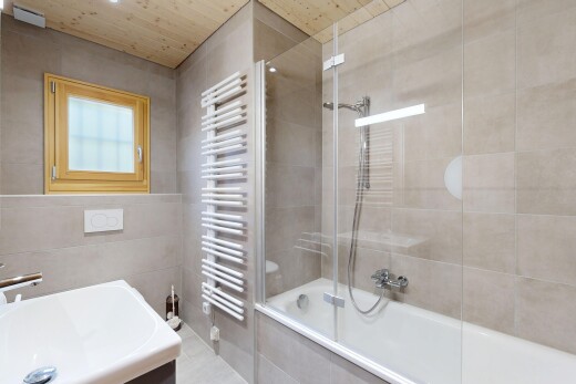 salle de bains avec chauffe-serviettes, douche-bain combinés, salle de bain complète, évier, et mur en carrelage