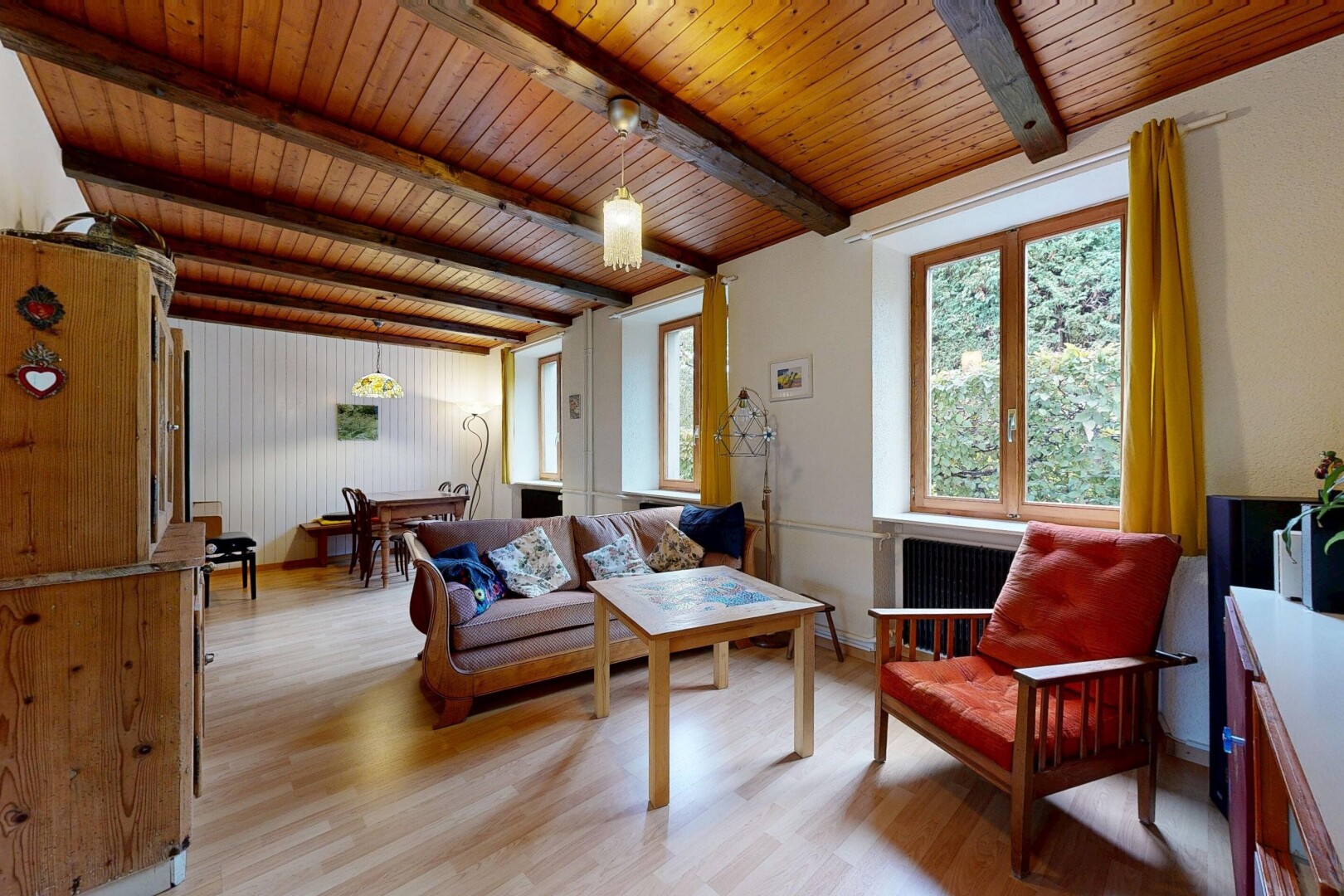 salon avec sol en finition bois, wood finish floor, inside property, plafond à poutres, et beamed ceiling