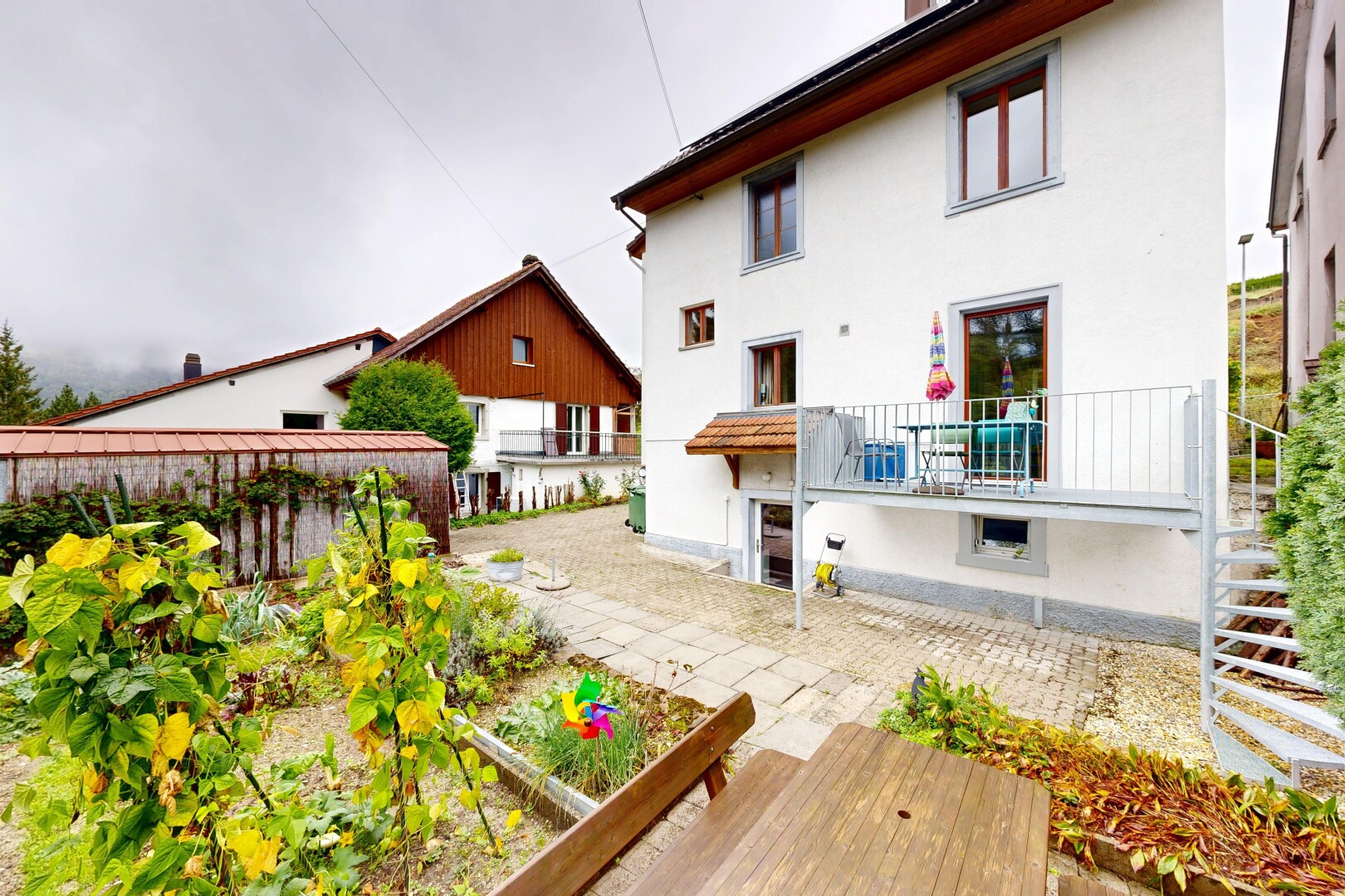 façade avec overcast, property visible, bardage en stuc, jardin, et escaliers
