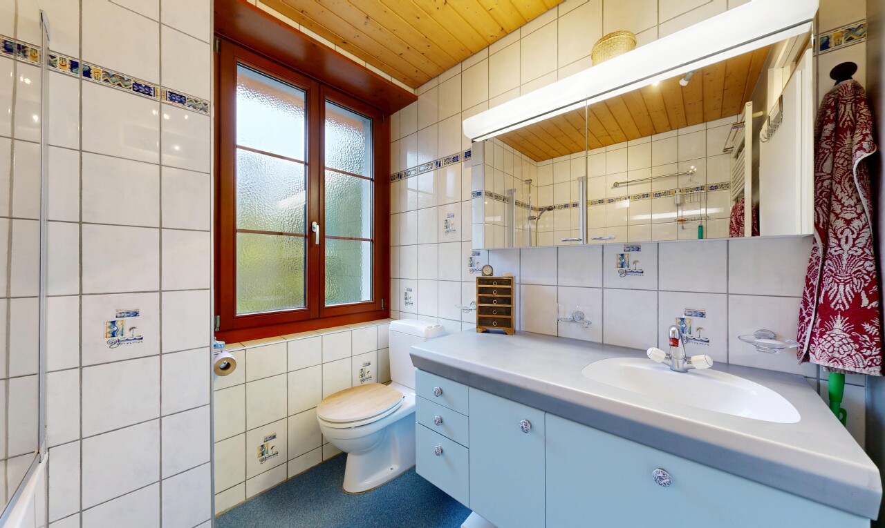 salle de bains avec tile wall, mur en carrelage, miroir, lavabo (ou coiffeuse selon le contexte), et inside property