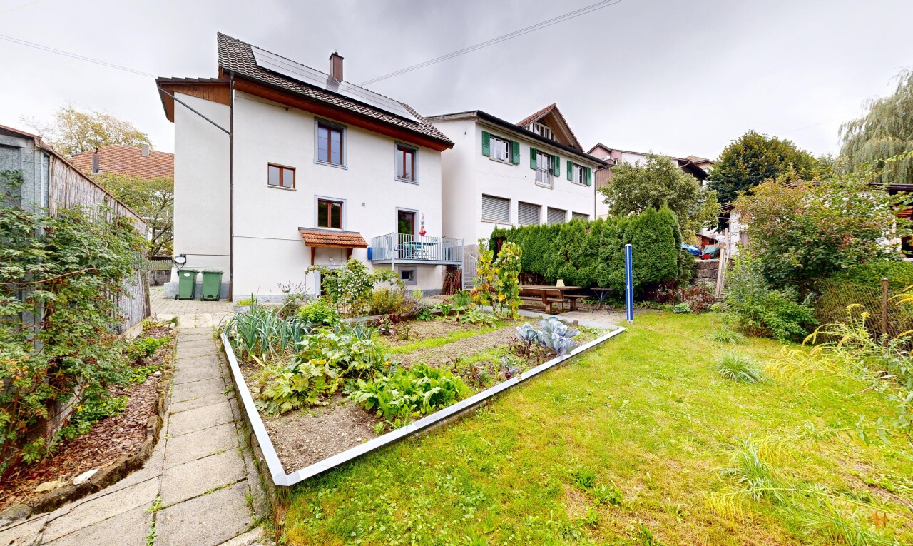 façade avec bardage en stuc, panneaux solaires, pelouse, overcast, et jardin