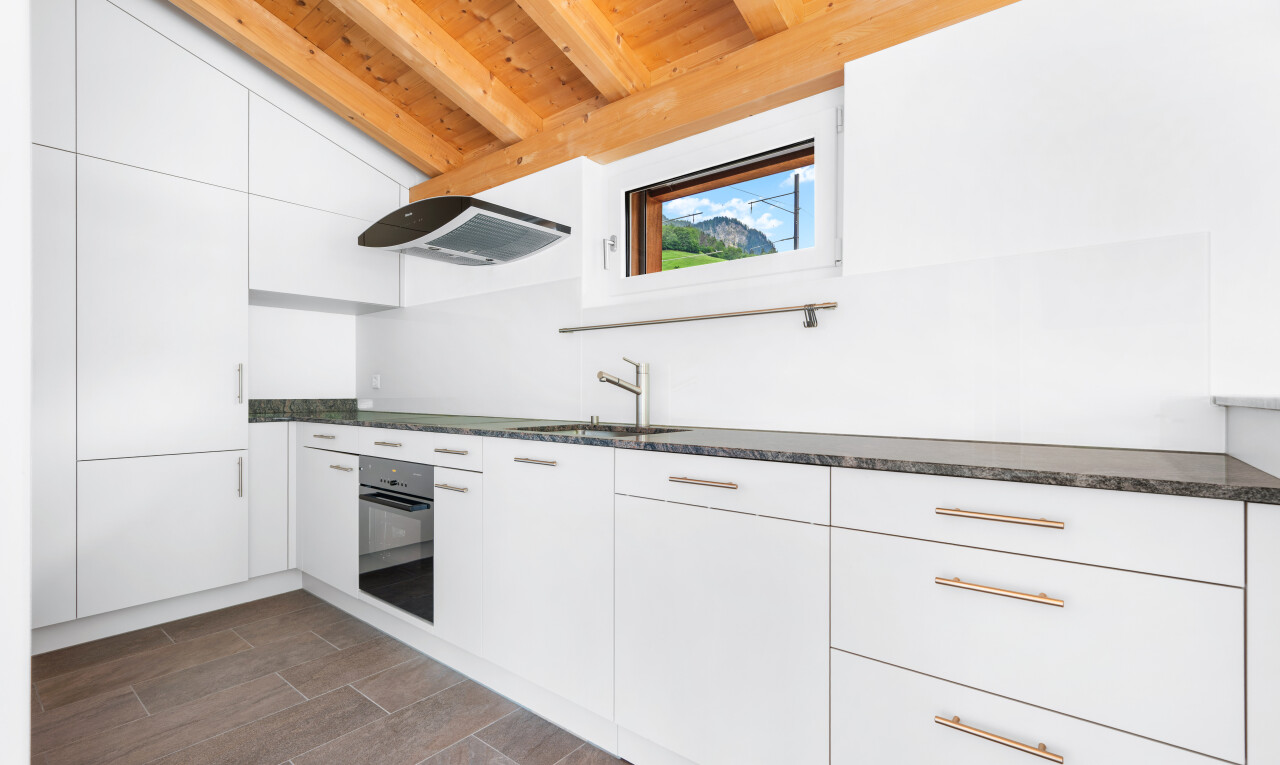 kitchen featuring white cabinetry, dark countertops, black oven, modern cabinets, and lofted ceiling with beams