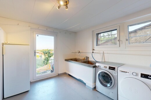 buanderie avec sol en béton, concrete floor, cloison sèche, drywall, et inside property