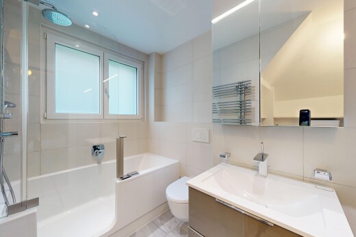 salle de bains avec tile wall, mur en carrelage, toilette, lavabo (ou coiffeuse selon le contexte), et salle de bain complète