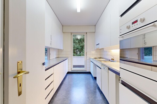 küche mit weiße schränke, ofen, finished concrete floor, inside property, und arbeitsplatten