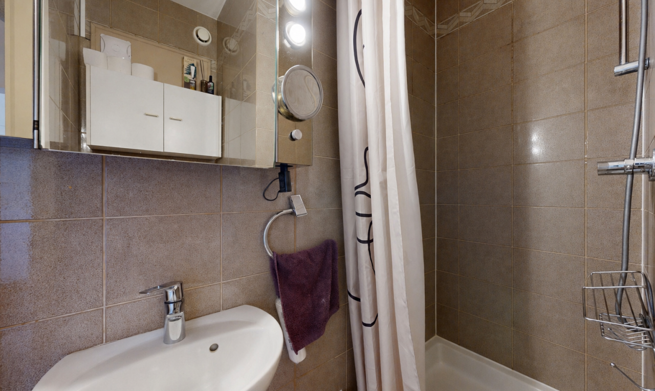 salle de bains avec tile wall, mur en carrelage, évier, miroir, et salle de bain complète