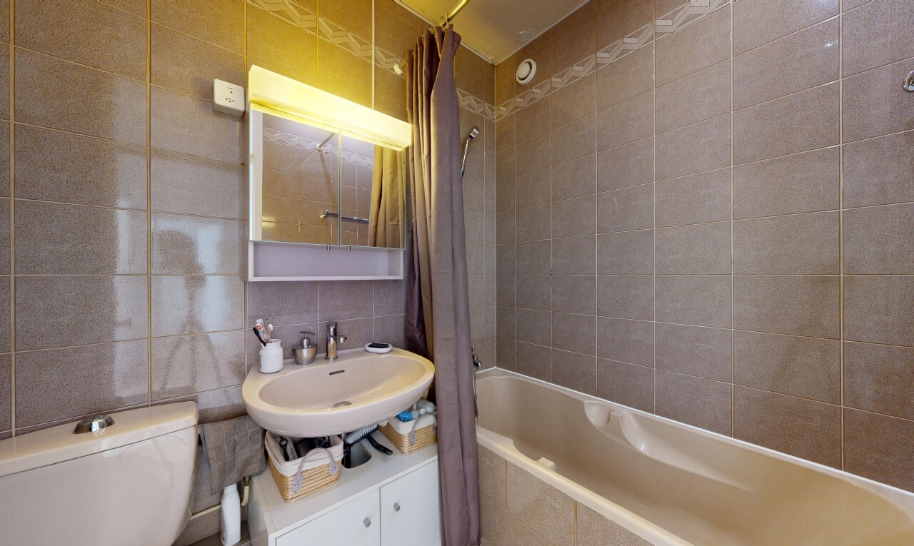 salle de bains avec miroir, mur en carrelage, tile wall, salle de bain complète, et toilette