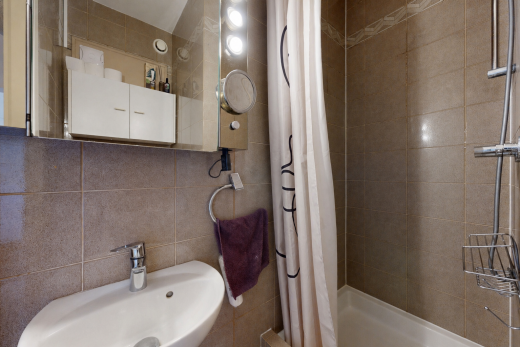 salle de bains avec tile wall, mur en carrelage, évier, miroir, et salle de bain complète