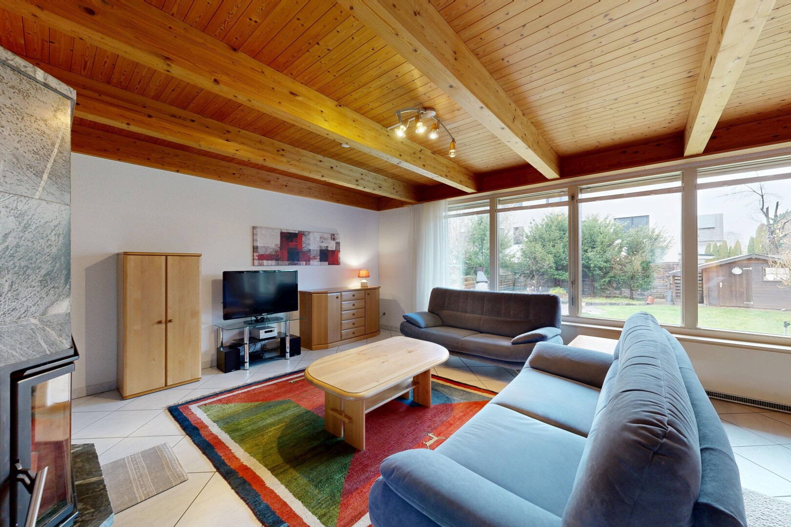 salon avec inside property, natural light, lumière naturelle, télévision, et beamed ceiling