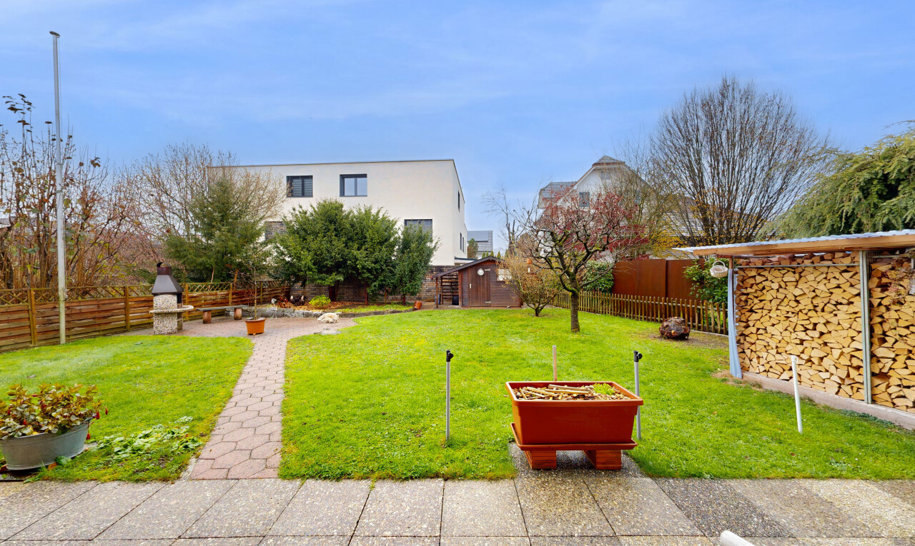 jardin avec clôture, day time, pelouse, property visible, et structure extérieure