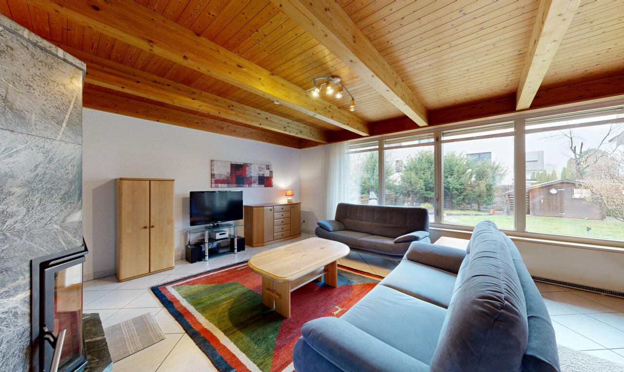 salon avec inside property, natural light, lumière naturelle, télévision, et beamed ceiling