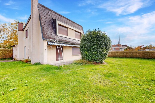 façade avec cheminée, pelouse, bardage en stuc, toit mansardé, et day time