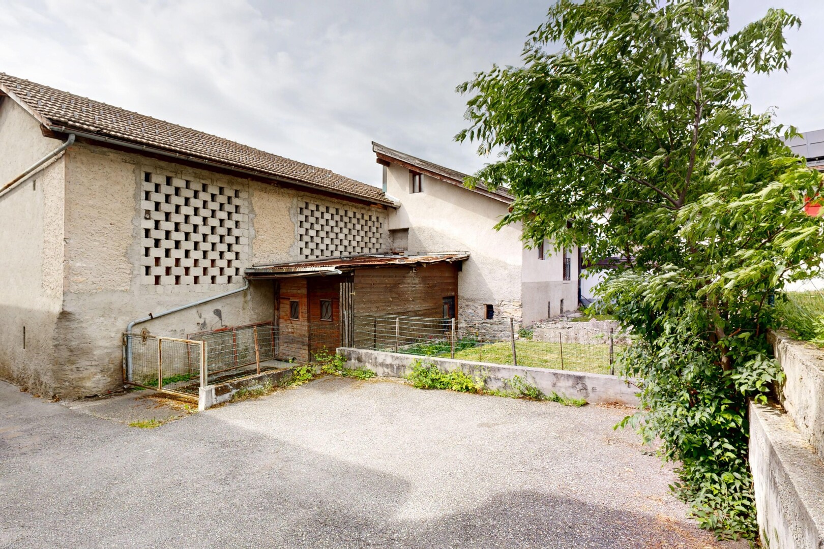 façade avec clôture, overcast, property visible, et bardage en stuc