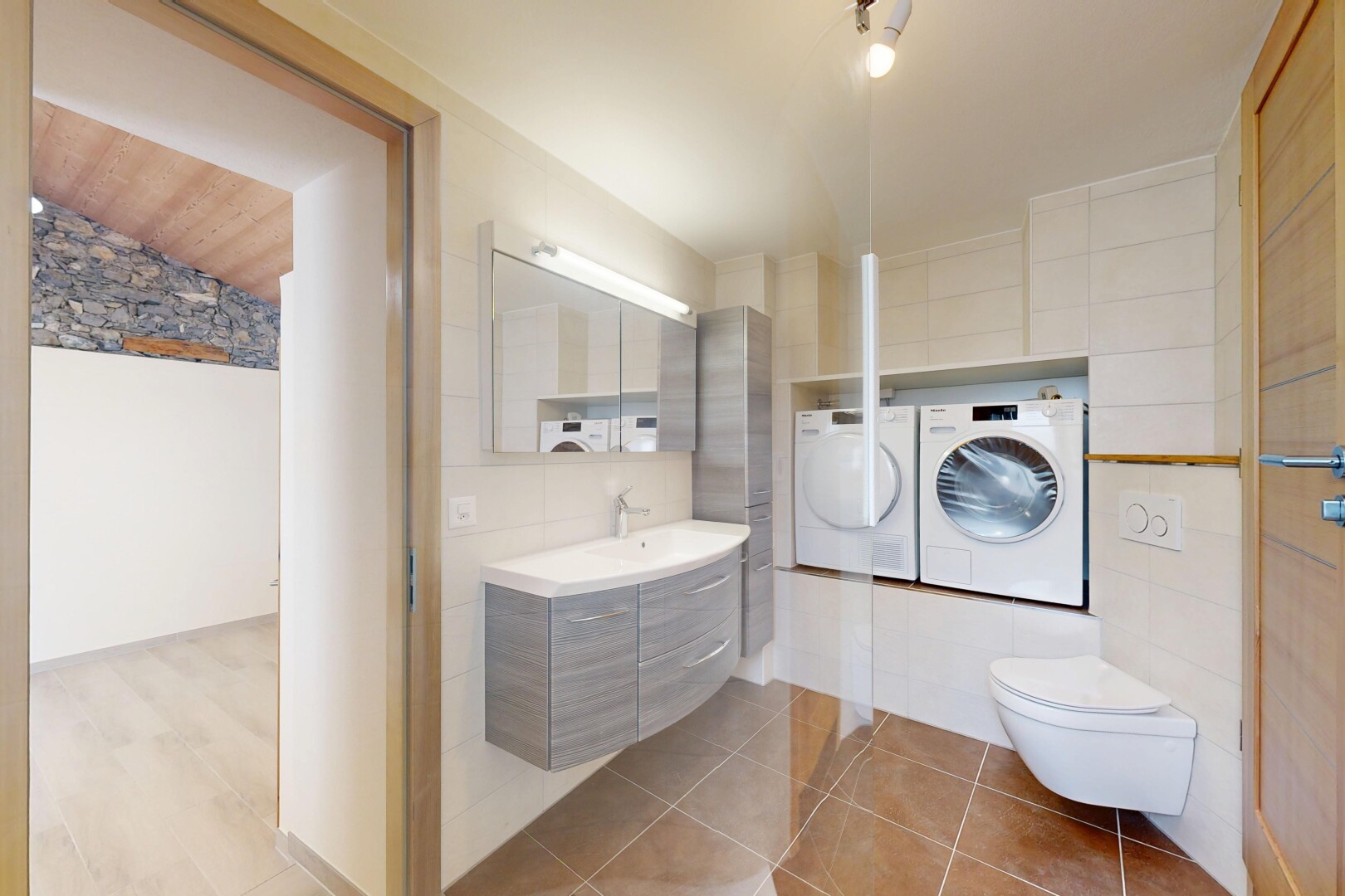 salle de bains avec miroir, lavabo (ou coiffeuse selon le contexte), mur en carrelage, tile wall, et inside property