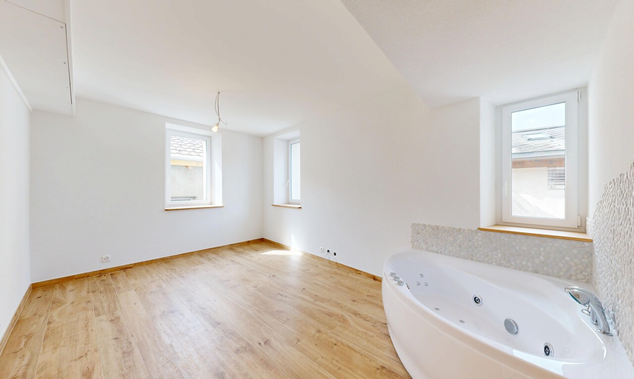 salle de bains avec bain, inside property, drywall, cloison sèche, et wood finish floor