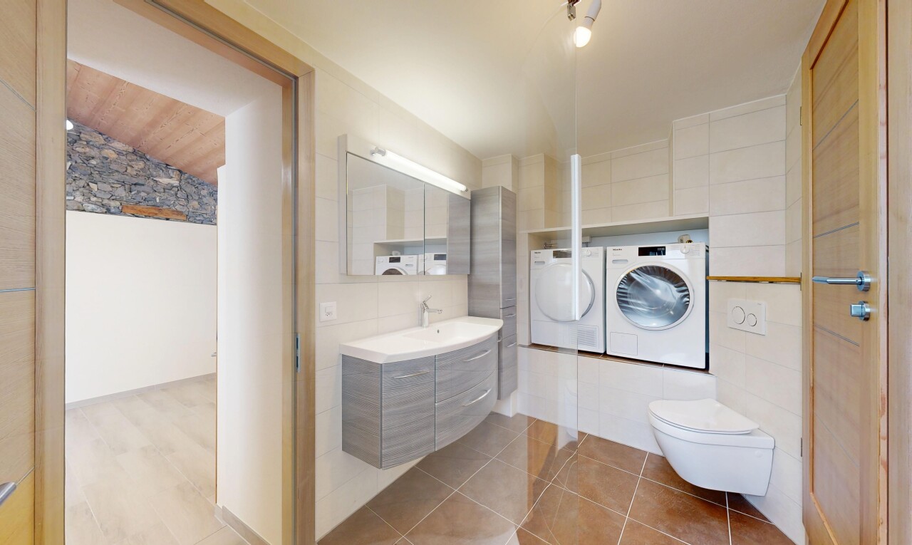 salle de bains avec miroir, lavabo (ou coiffeuse selon le contexte), mur en carrelage, tile wall, et inside property