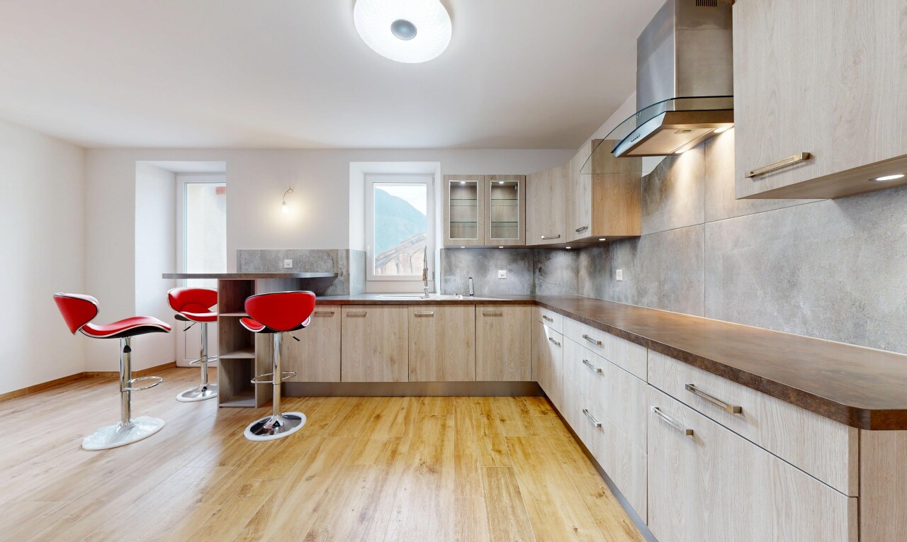 cuisine avec hotte, backsplash, dosseret, light floor, et dark countertops