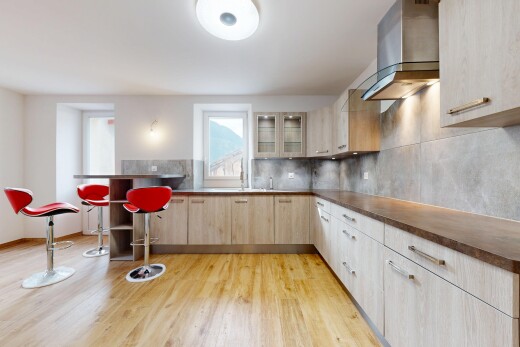 cuisine avec hotte, backsplash, dosseret, light floor, et dark countertops