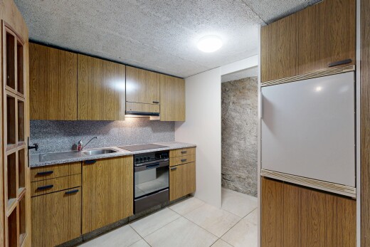 cuisine avec four, light floor, tile floor, sol en carrelage, et medium brown cabinets