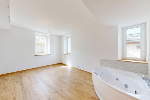 salle de bains avec bain, inside property, drywall, cloison sèche, et wood finish floor