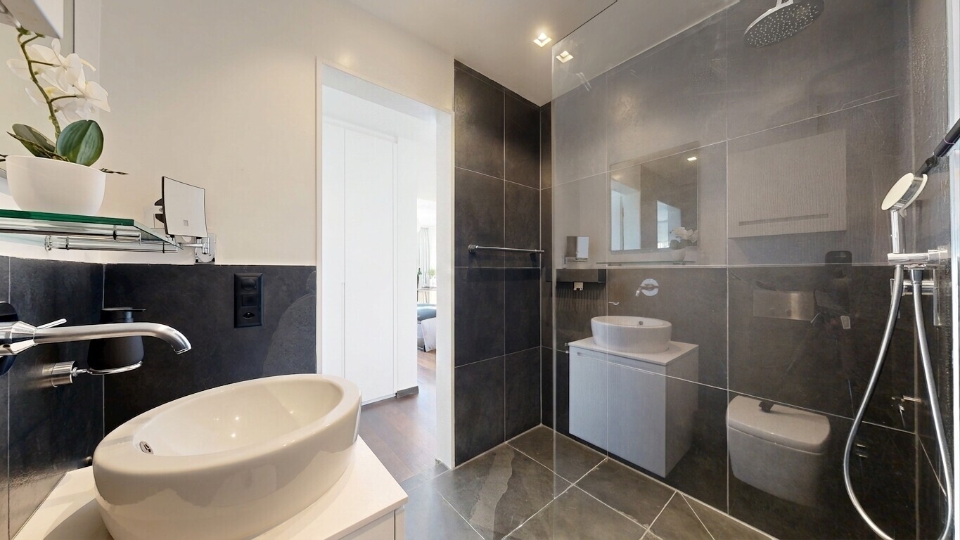 salle de bains avec lavabo (ou coiffeuse selon le contexte), salle de bain complète, miroir, évier, et douche