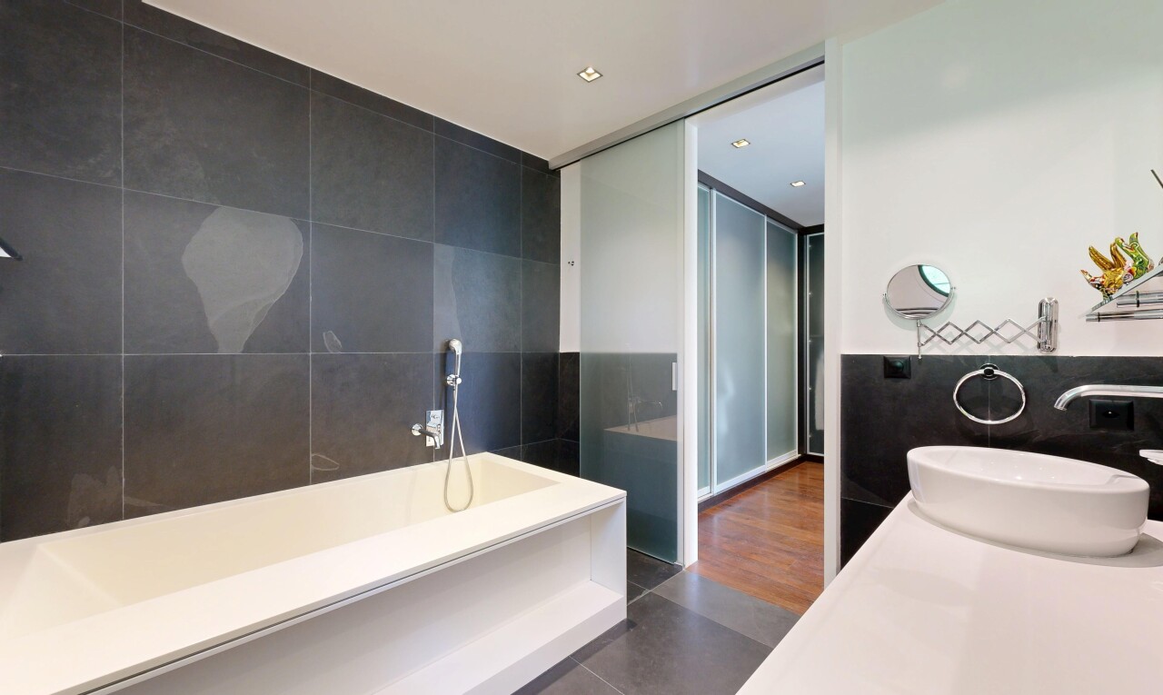 salle de bains avec tile wall, mur en carrelage, salle de bain complète, évier, et dark floor
