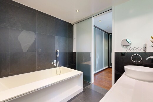 salle de bains avec tile wall, mur en carrelage, salle de bain complète, évier, et dark floor