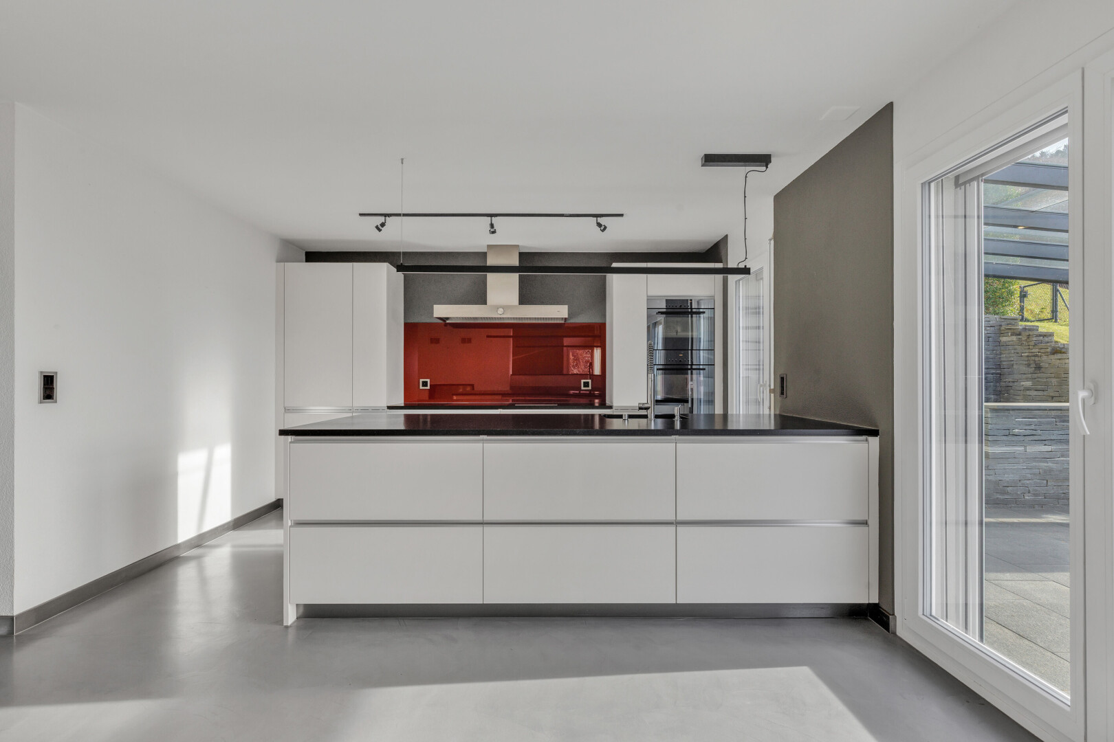 küche mit küchentheke, schränke mit flachen paneelen, drywall, gipskartonwand, und finished concrete floor