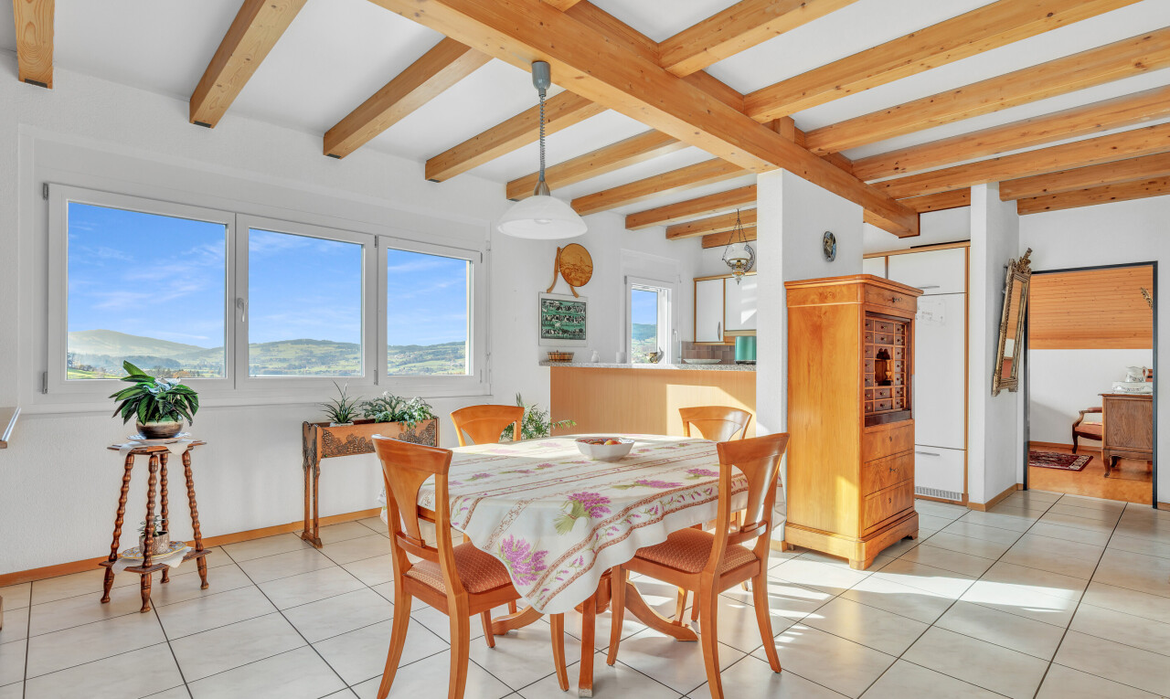 dining area with beam ceiling and light tile patterned floors