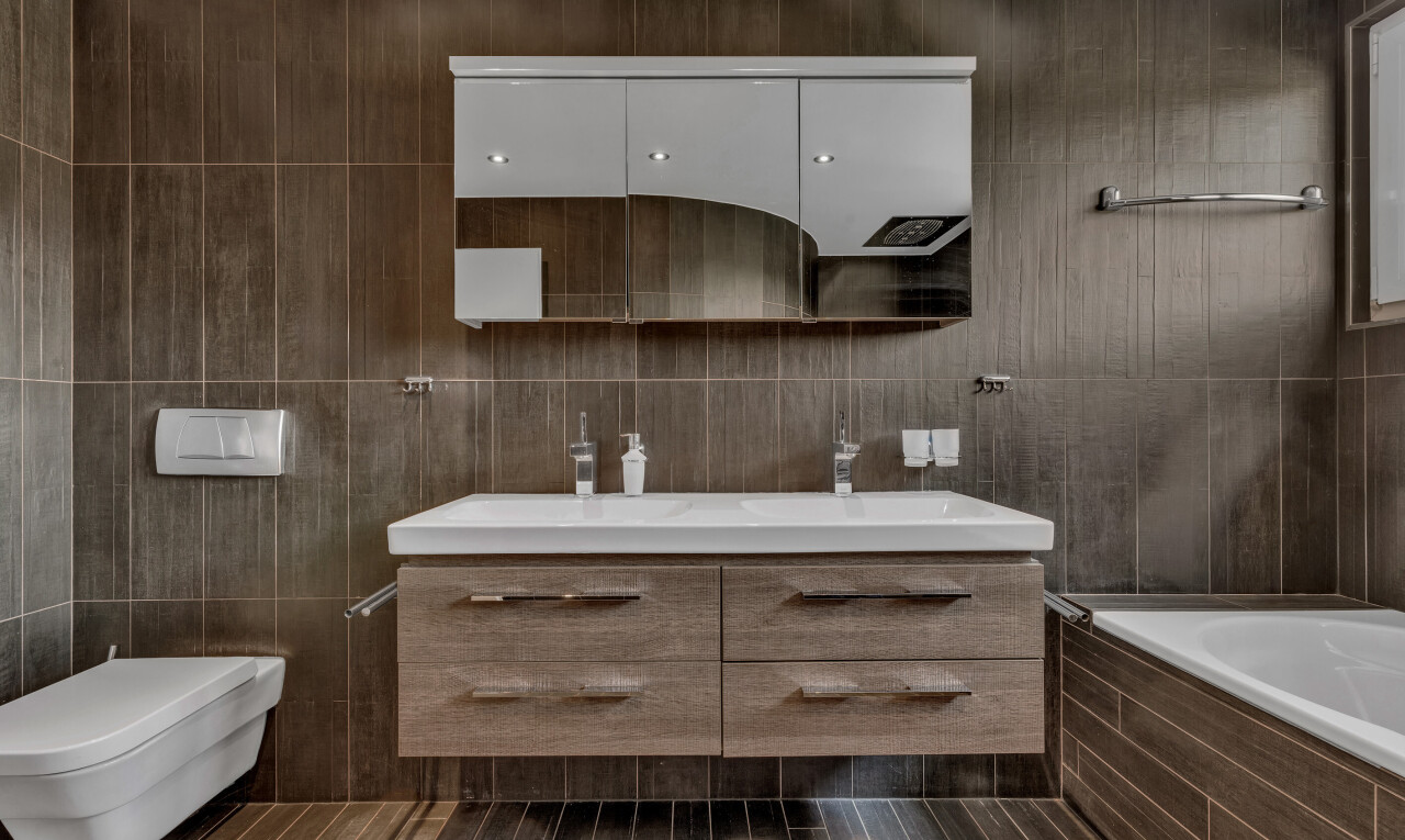 full bathroom with vanity, a relaxing tiled tub, and tile walls