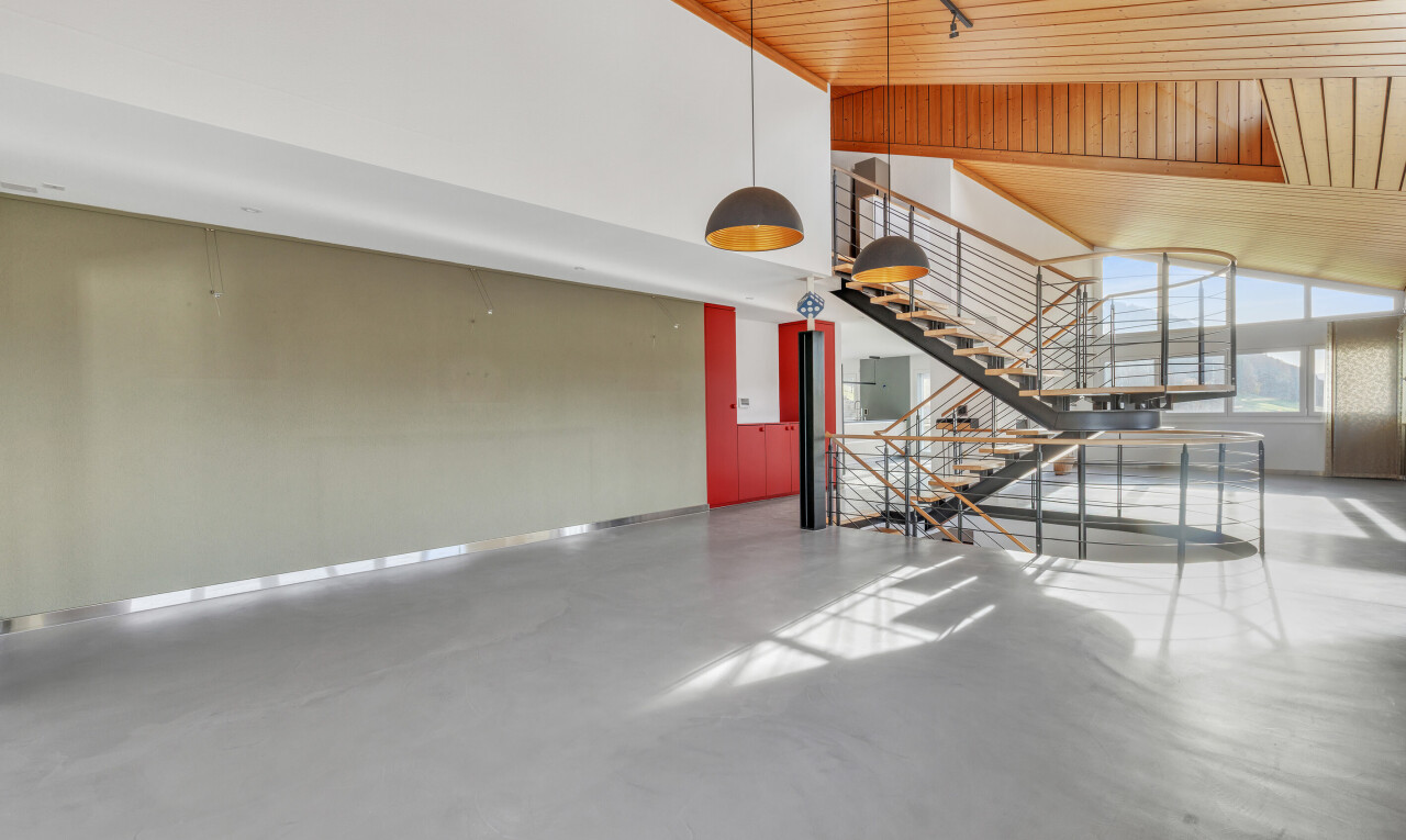 stairway featuring concrete flooring, wood ceiling, a towering ceiling, and track lighting