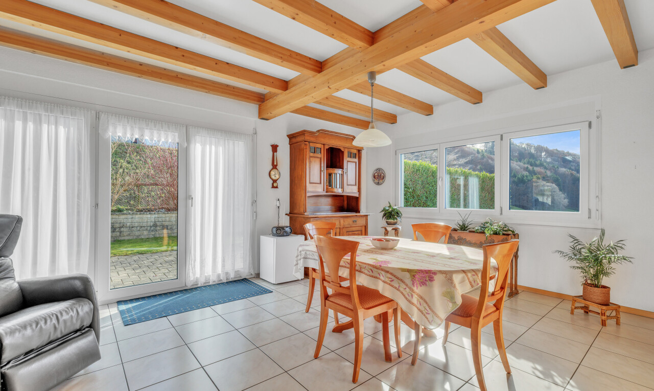 dining space with light tile patterned floors and beamed ceiling