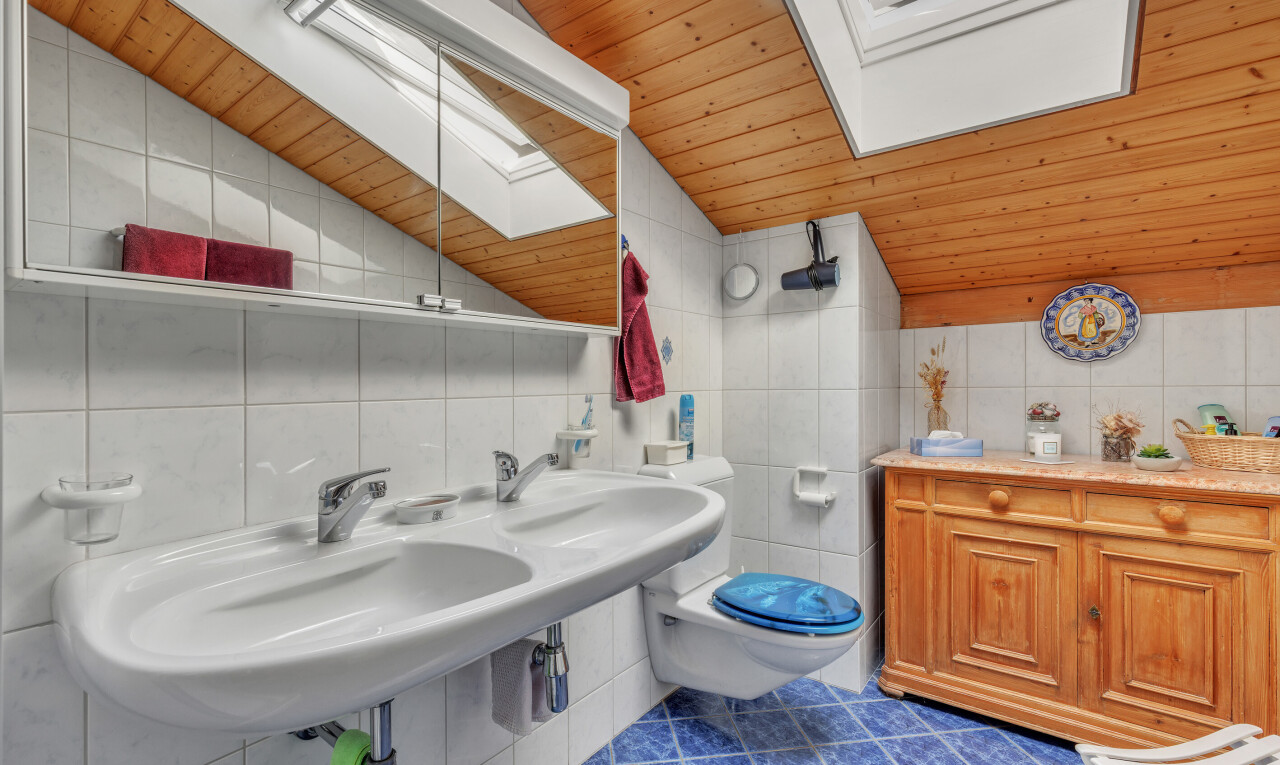 bathroom with wooden ceiling, vaulted ceiling, tile walls, a skylight, and dark tile patterned flooring