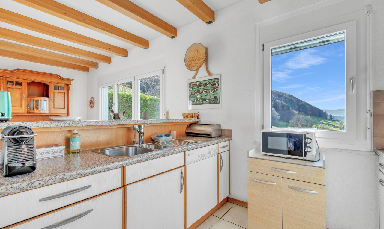 kitchen with white appliances, light tile patterned flooring, beam ceiling, light brown cabinets, and white cabinets