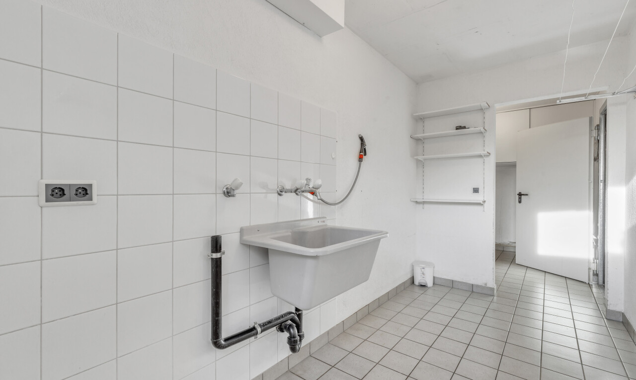 buanderie avec inside property, évier, sol en carrelage, tile floor, et cloison sèche
