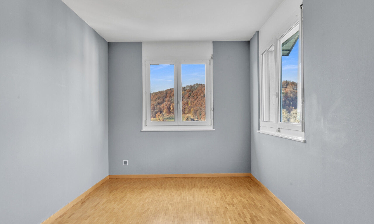 spare room featuring baseboards and wood finished floors