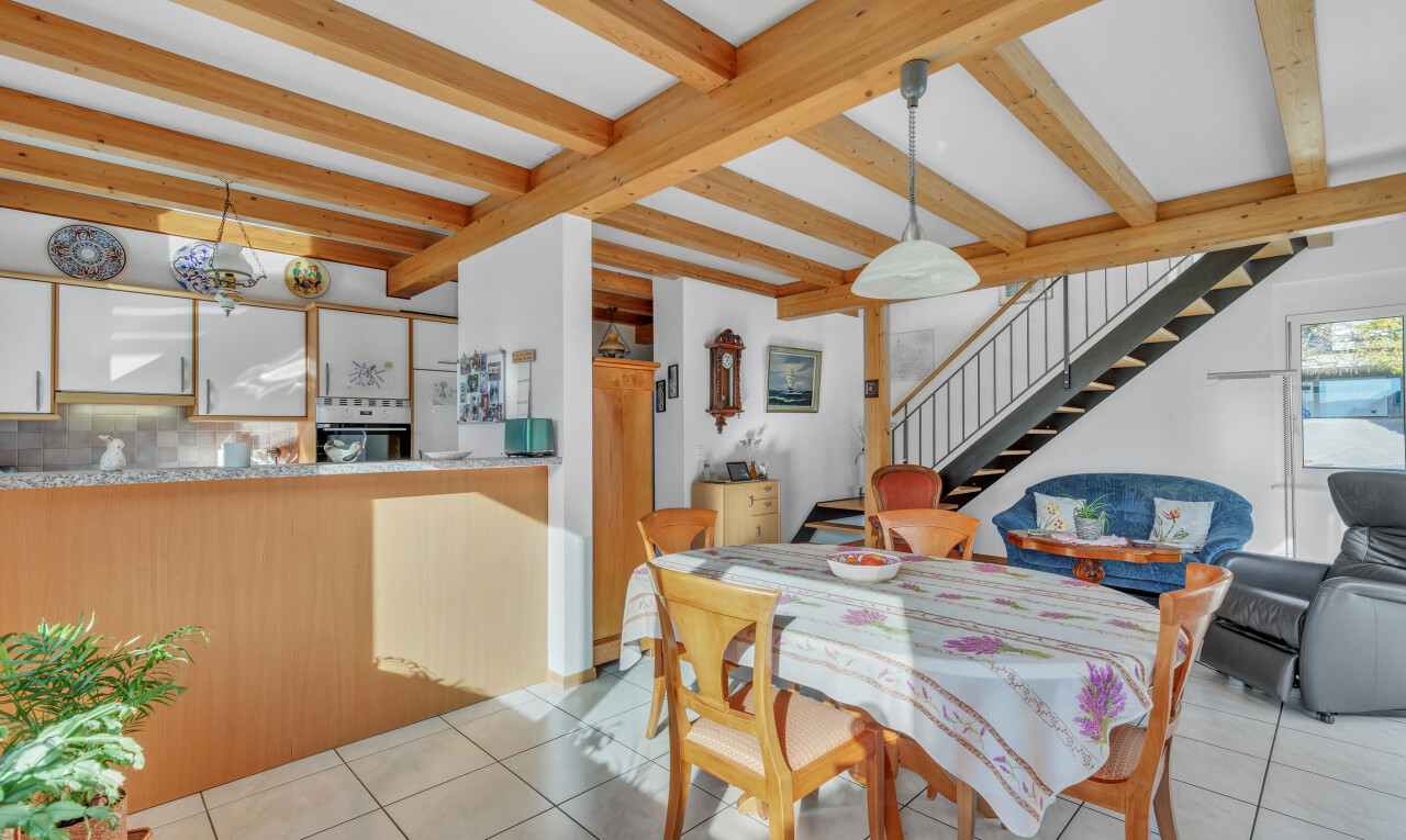 tiled dining space featuring stairs and beam ceiling