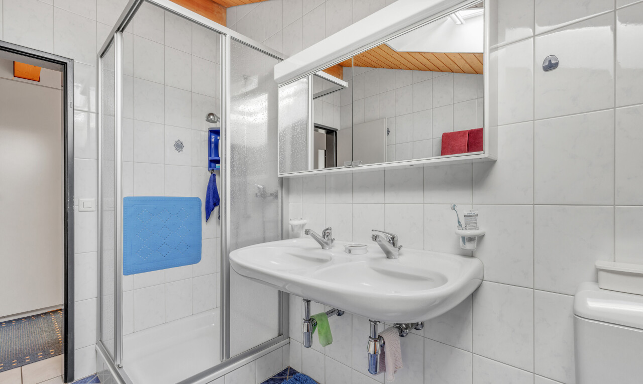 full bathroom with tile walls, a shower stall, and wooden ceiling