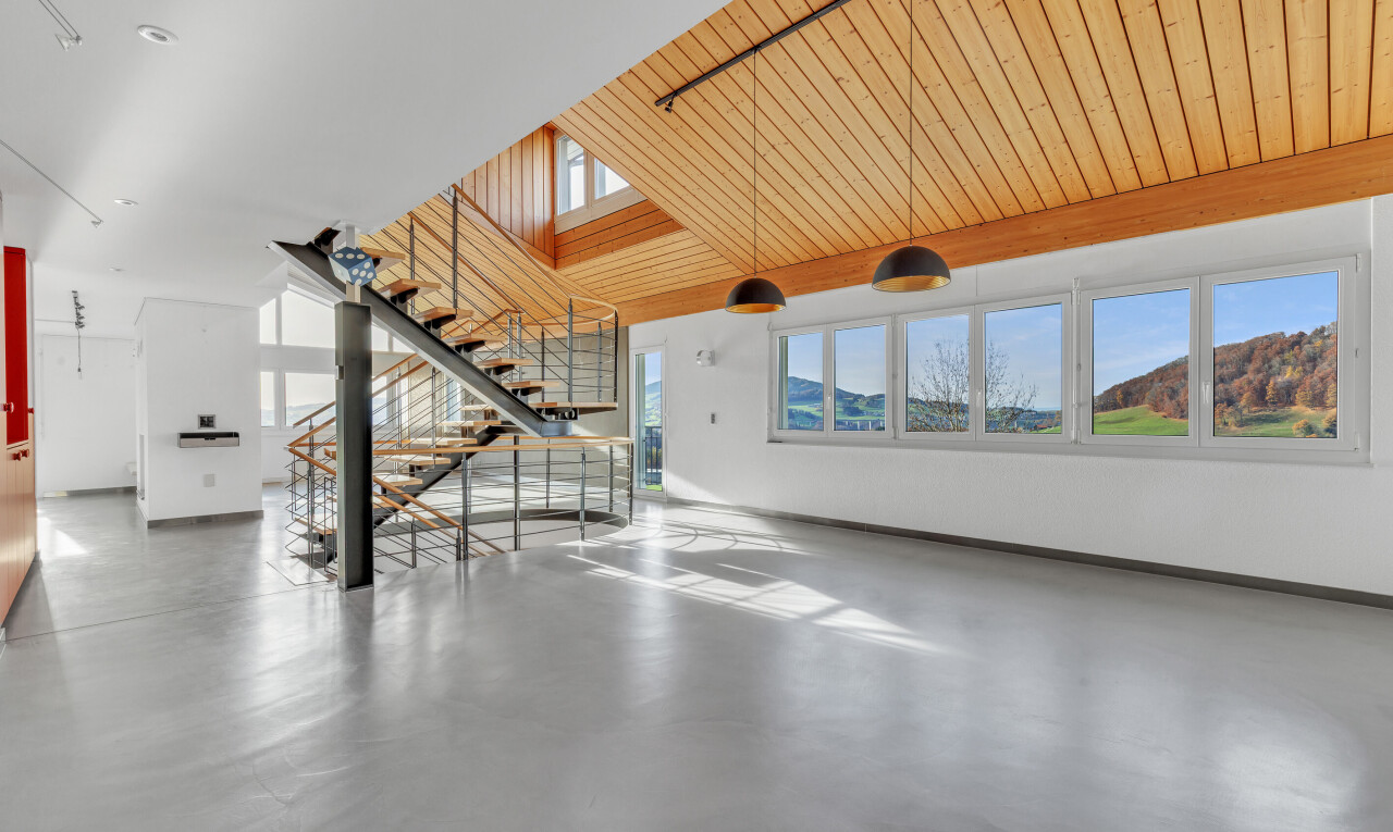 stairway with healthy amount of natural light, finished concrete floors, and wood ceiling