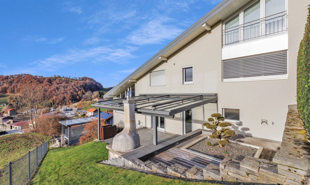 outdoor house with stucco siding, a patio area, and a pergola