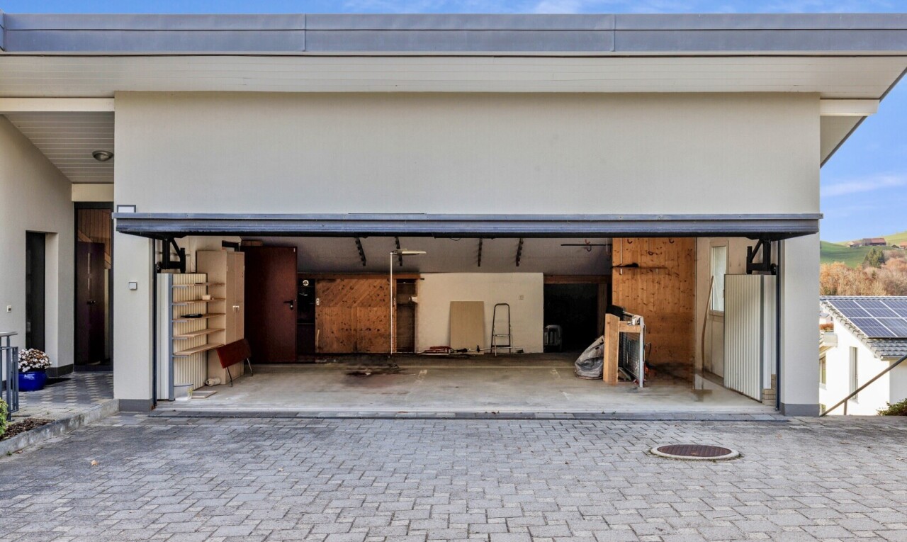 patio / terrace with a garage, a patio, and decorative driveway