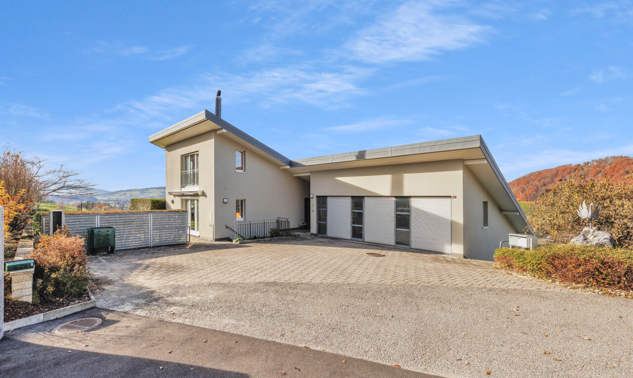 view of home with stucco siding, a mountain view, and driveway