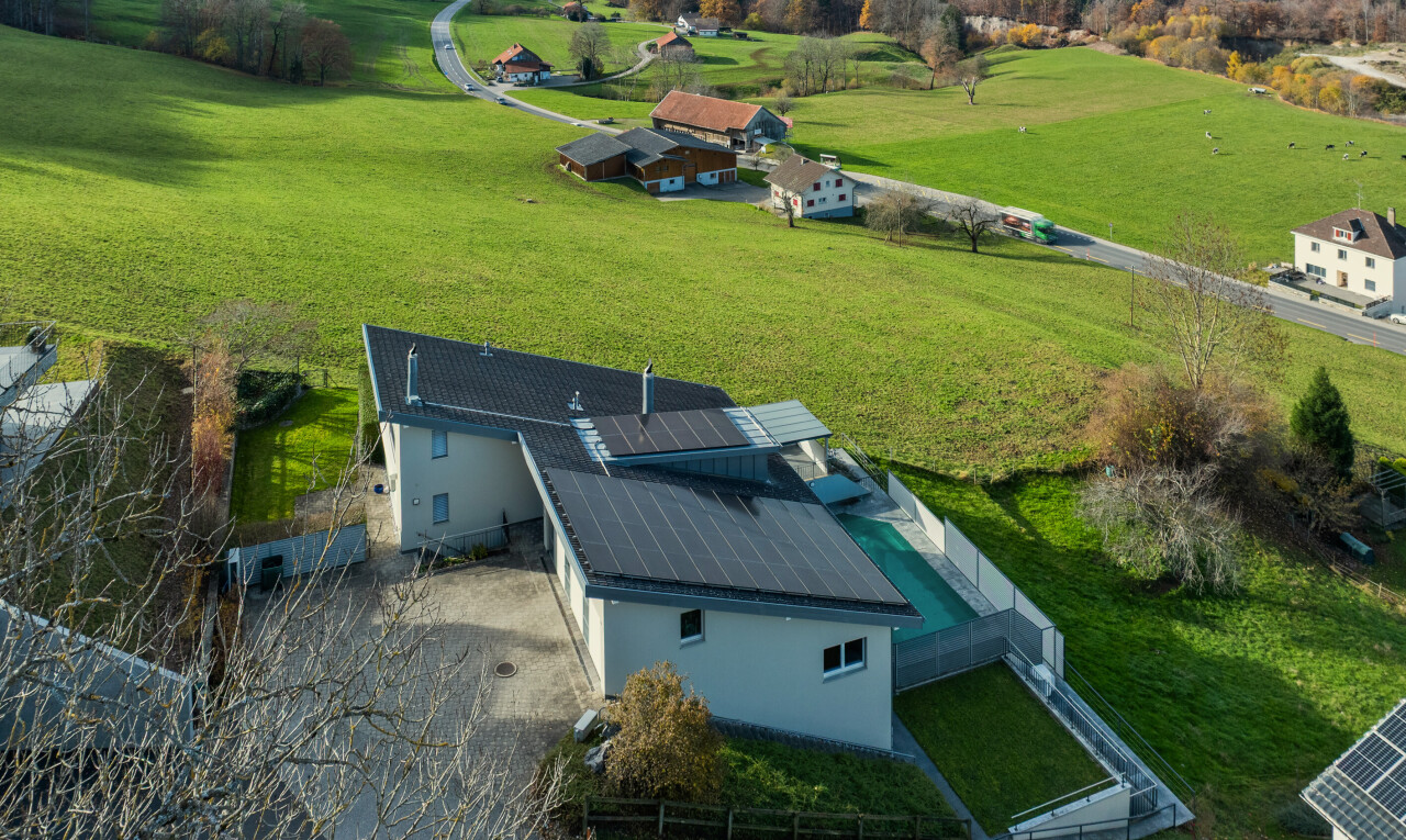 façade avec panneaux solaires, property visible, clôture, et pelouse