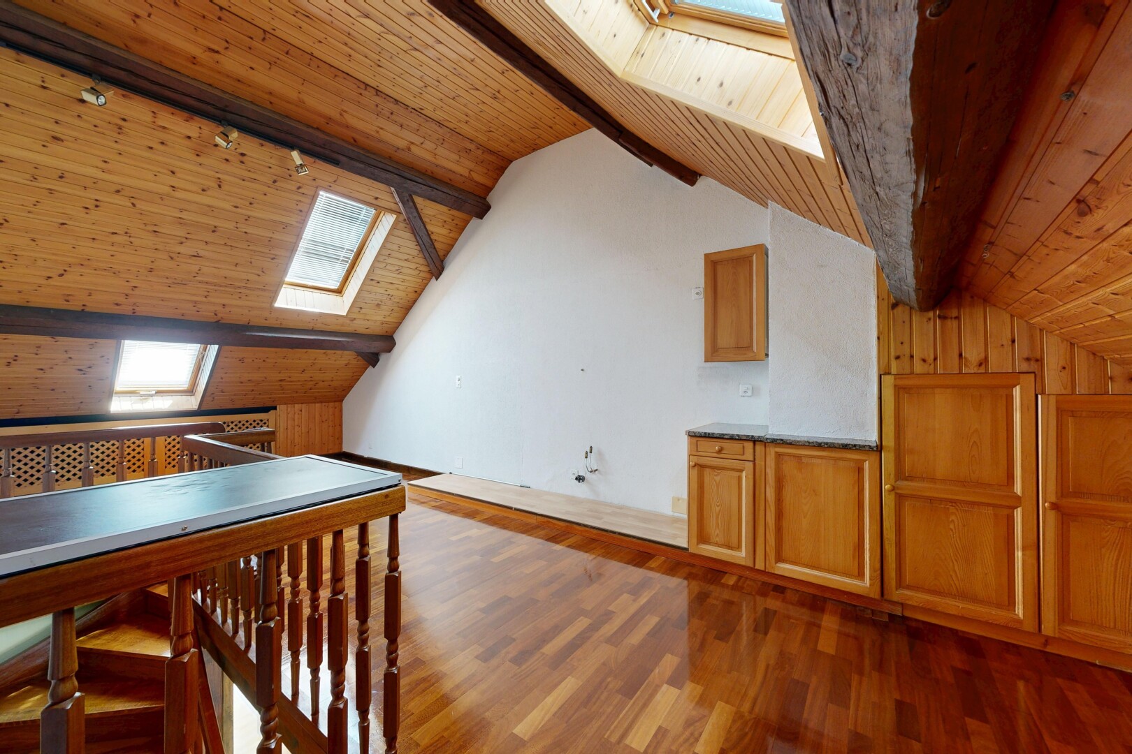 salle à manger avec puits de lumière, plafond à poutres, beamed ceiling, sol en finition bois, et wood finish floor