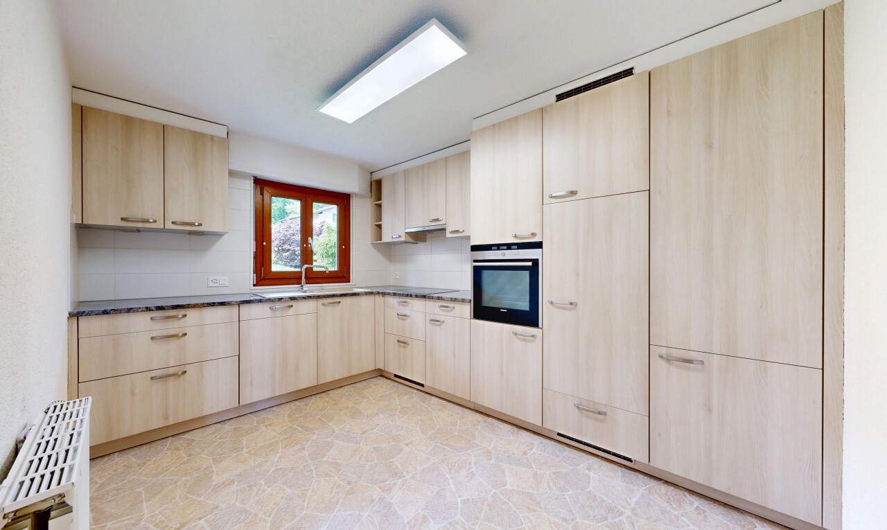 cuisine avec armoires marron clair, light brown cabinets, four, light floor, et lumière naturelle