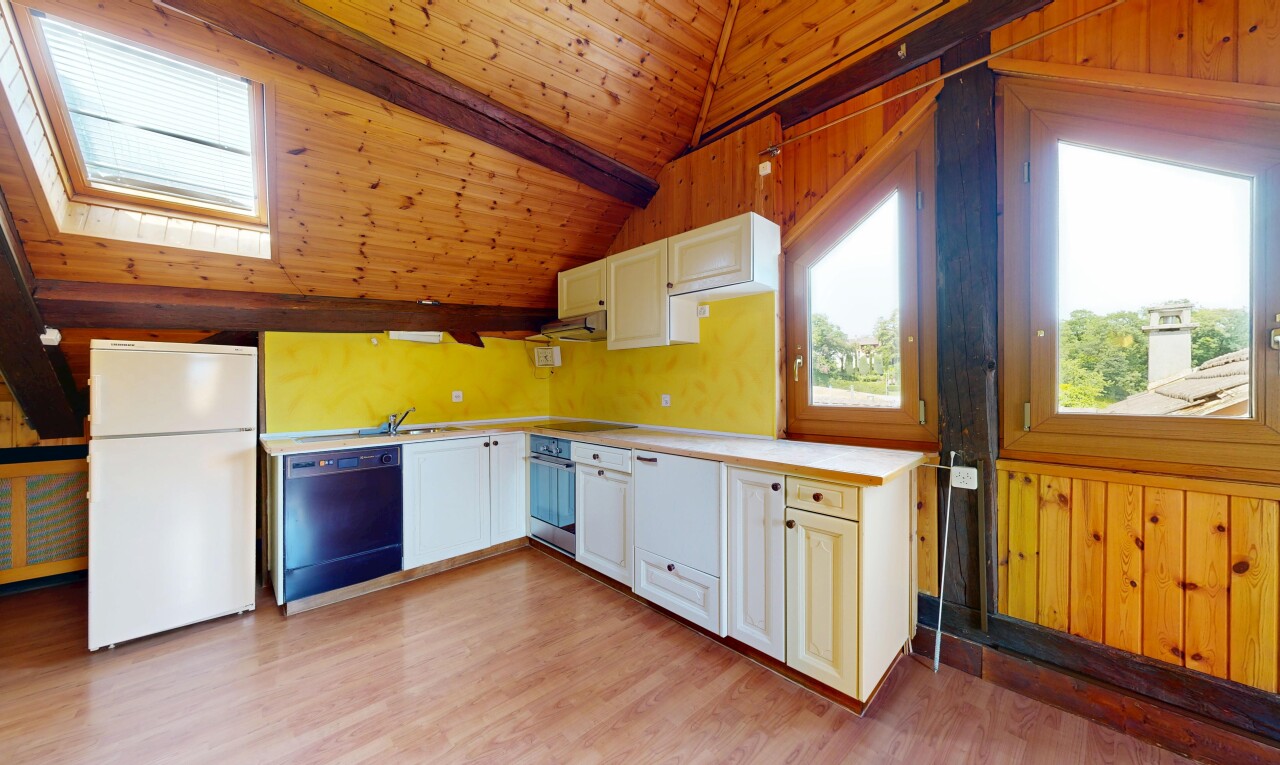 cuisine avec réfrigérateur, plans de travail, light countertops, mur en bois, et wood wall