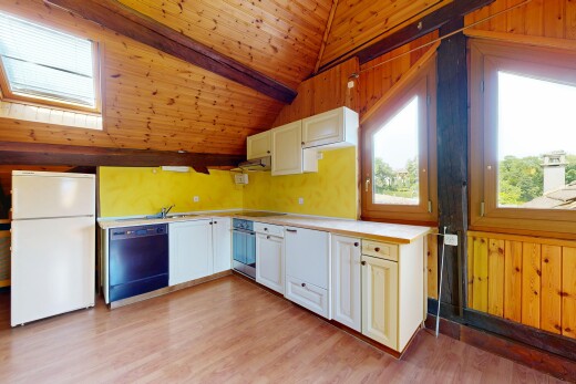 cuisine avec réfrigérateur, plans de travail, light countertops, mur en bois, et wood wall