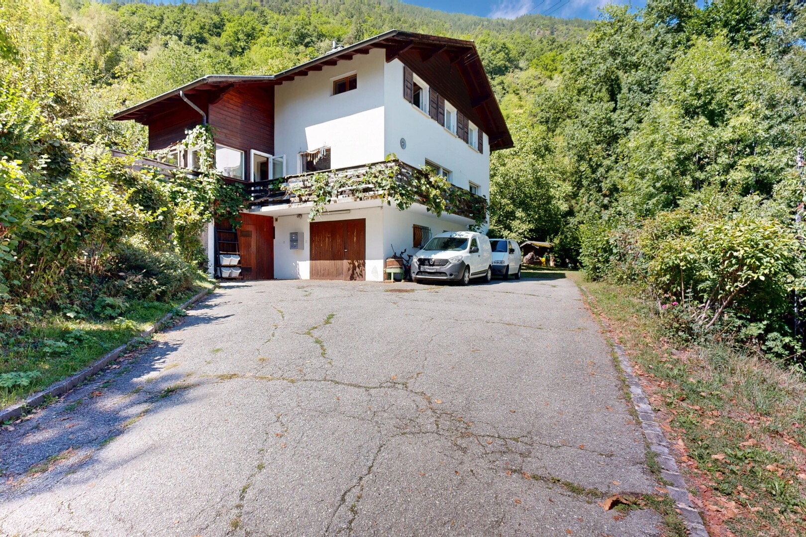 façade avec allée, forest view, vue sur la forêt, property visible, et day time